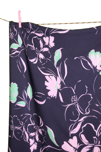 Donkerblauwe viscose met lila en groene bloemen - €26/m